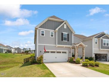Charming two-story home with a well-maintained lawn and attached two-car garage at 209 Sage Oak Ln, Holly Springs, NC 27540