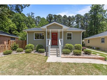 Charming single-story home showcasing a red door and lush landscaping at 2712 Broad St, Durham, NC 27704