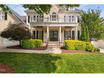 Elegant home featuring a stone facade, welcoming porch, and manicured landscaping at 3004 Montville Valley Ct, Cary, NC 27519
