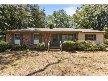 Charming single-story brick home featuring green shutters and a well-maintained front yard at 4038 Redwood Rd, Durham, NC 27704