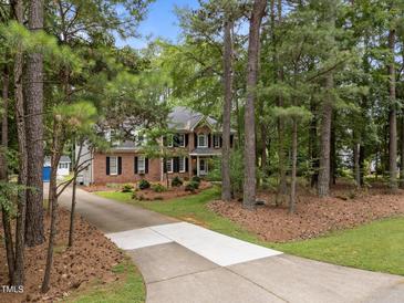Traditional two-story brick home with mature landscaping and a long driveway at 5109 Makena Dr, Raleigh, NC 27615