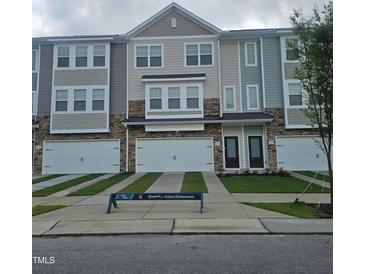 View of newly constructed townhomes with multi-toned exterior and private driveways at 5334 River Reach Dr, Raleigh, NC 27616