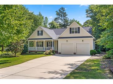 Charming single-story home with a well-manicured lawn, covered porch, and two-car garage at 59 Carrousel Ct, Angier, NC 27501