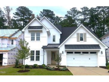 Beautiful two-story white home with a black metal awning, two-car garage, and well-manicured lawn at 9176 Dupree Meadow Dr # 17, Angier, NC 27501