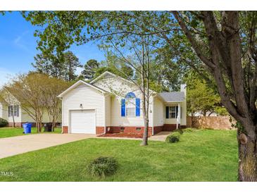 Charming single-story home with a well-manicured lawn, attached garage, and beautiful landscaping at 96 Landmark Dr, Angier, NC 27501