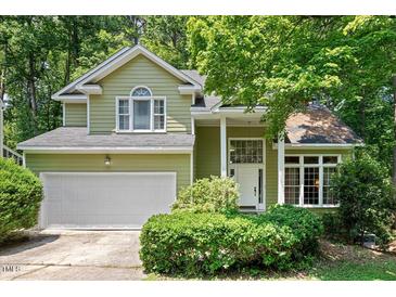 Charming two-story home featuring a two-car garage and a well-maintained front yard with mature landscaping at 107 Canyon Run, Cary, NC 27513