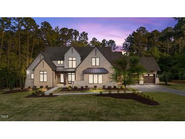 Stunning two-story stone home featuring manicured lawn and a side-entry garage on a wooded lot at 15517 Possum Track Rd, Raleigh, NC 27614