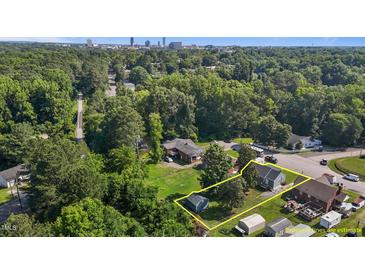 Expansive aerial view of property showcasing mature trees, spacious yard, and proximity to downtown skyline at 1818 Cecil St, Durham, NC 27707