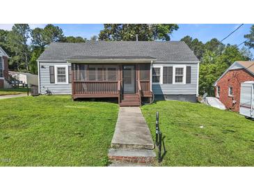 Charming single-story home with a screened-in porch and well-maintained front yard at 1818 Cecil St, Durham, NC 27707