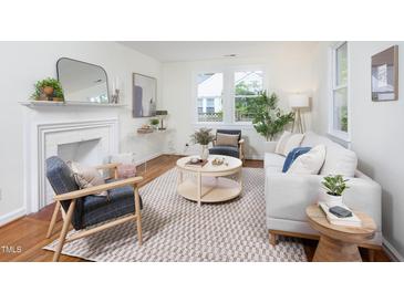 Bright living room with fireplace, stylish furniture, large windows, and beautiful hardwood floors at 2523 Glendale Ave, Durham, NC 27704