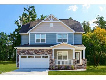 Charming two-story home featuring stone accents, a covered porch, and an attached two-car garage at 301 Sawgrass Ct, Mebane, NC 27302