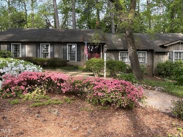 Charming single story home surrounded by lush flowering shrubs and mature trees, offering great curb appeal at 36A Country Club Dr, Rocky Mount, NC 27804