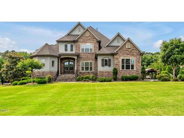 Beautiful, professionally landscaped home with stone and a large, well-manicured front yard at 6250 Moinear Ln, Chapel Hill, NC 27514