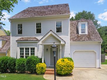 Charming two-story home with shake siding, a front porch, and mature landscaping under a blue sky at 137 Wintermist Dr, Cary, NC 27513
