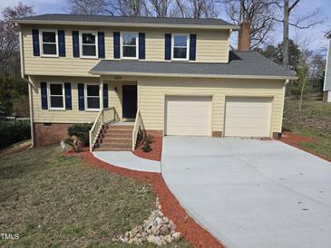 Charming two-story home featuring a well-manicured lawn, new driveway, and an attached two-car garage at 309 Wyatts Pond Lane, Cary, NC 27513