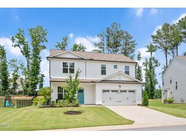 Charming two-story home featuring a bright blue front door, well-manicured lawn and attached two-car garage at 31 Pascoli Ct, Clayton, NC 27527