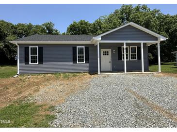 Charming home featuring gray siding, black shutters, and a welcoming front porch area at 311 W Market St, Graham, NC 27253