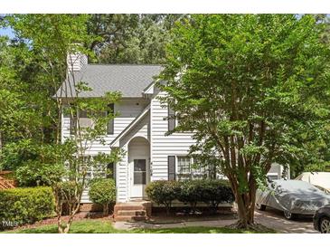 Charming two-story home with white siding, mature trees, manicured landscaping, and an inviting front entrance at 4108 Lazyriver Ln, Durham, NC 27712