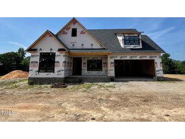 New construction featuring a brick base and a modern, open garage at 6332 River Rd, Fuquay Varina, NC 27526