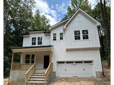 New two story home with an attached two car garage and a cozy front porch and stone steps at 701 Locust Ln, Raleigh, NC 27603