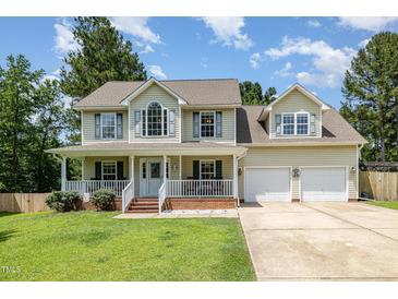 Charming two-story home with a welcoming front porch and well-manicured lawn at 105 Rolling Stone Ct, Sanford, NC 27332