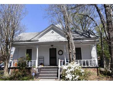 Charming white home featuring a welcoming front porch, traditional architecture, and inviting curb appeal at 1301 E Jones St, Raleigh, NC 27610