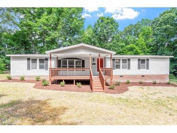 Charming single-story home boasts a welcoming front porch and well-maintained landscaping at 141 S Creek Dr, Louisburg, NC 27549