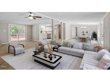 Spacious living room with a ceiling fan, modern furniture, and plenty of natural light at 141 S Creek Dr, Louisburg, NC 27549