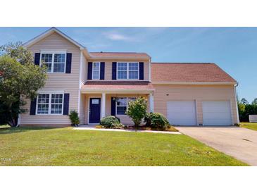 Charming two-story home features a two-car garage, complemented by lush greenery and vibrant landscaping at 417 Downing Glen Dr, Morrisville, NC 27560