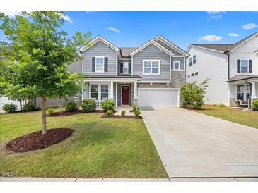 Charming two-story home with manicured lawn, gray siding, stone accents, and a two-car garage at 4508 Valley Crest Ln, Fuquay Varina, NC 27526