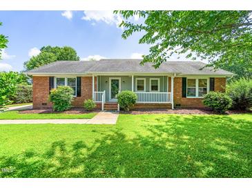 Charming brick ranch home with a cozy front porch and well-manicured lawn in a peaceful neighborhood at 5 Windsor Pl, Mebane, NC 27302