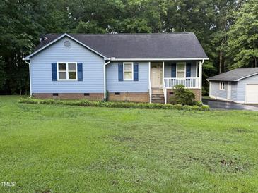 Charming single-Gathering home with light blue siding, dark shutters, and a manicured lawn at 535 Hillcrest Dr, Garner, NC 27529