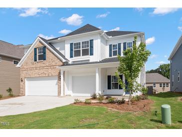 Charming two-story home with white siding, brick accents, a three-car garage, and a well-manicured lawn at 84 Black Walnut Dr # 200, Garner, NC 27529