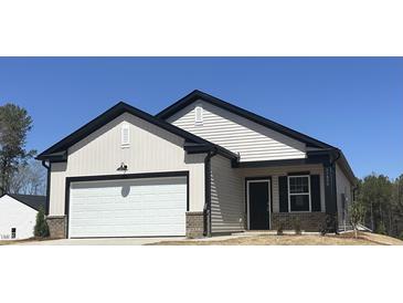 New construction home showcasing light siding, black trim, a two-car garage, and an inviting front entrance at 11198 Salers Loop, Middlesex, NC 27557