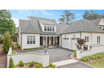 Stunning white brick home features a charming drive and attached two-car garage at 1312 Duplin Rd, Raleigh, NC 27607