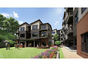 Modern apartments featuring a communal outdoor green space with a grill, seating, and manicured landscaping at 140 Two Hills Dr # 302C, Carrboro, NC 27510