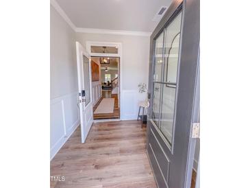 Inviting entryway with an open door and paneled wall leading to the living area and wood-look floors at 523 Beacon Hill Rd # 31, Lillington, NC 27546