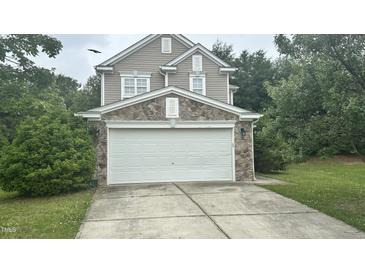 Charming two-story home with a stone accented garage and a well-maintained lawn at 6005 Namozine Ct, Raleigh, NC 27610