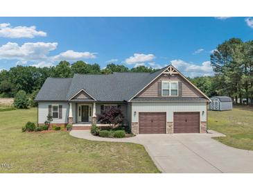 Charming two-story home featuring a two-car garage, manicured lawn, and inviting front porch at 7055 Nc-242, Dunn, NC 28334