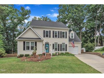 Charming two-story home with manicured lawn, brick-lined driveway, and inviting curb appeal at 7613 Percy Ct, Raleigh, NC 27613