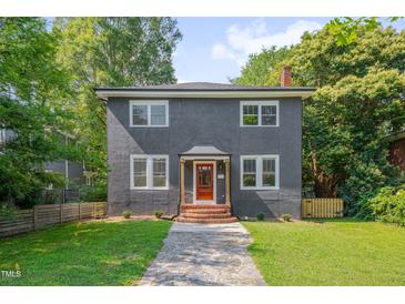 Charming two-story home featuring a stucco facade, brick steps, and a well-manicured lawn at 924 W Trinity Ave, Durham, NC 27701