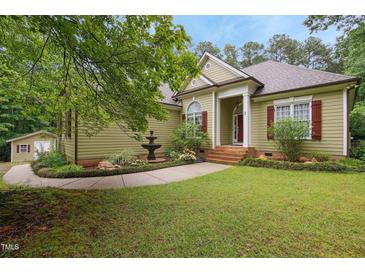 Charming home featuring a fountain and a lush landscaped yard with a well-maintained lawn at 109 Springwood Dr, Wake Forest, NC 27587