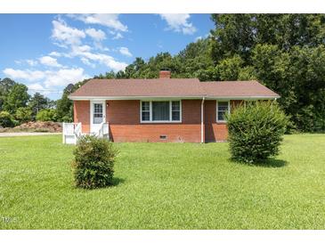 Charming brick home with well-maintained lawn and mature trees offering classic curb appeal at 1209 Bobbitt Dr, Garner, NC 27529