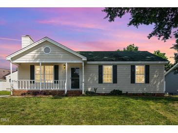 Charming single-story home with a front porch, green lawn, and freshly painted exterior at 2108 Carthage Cir, Raleigh, NC 27604