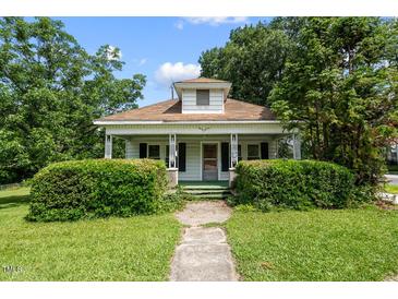 Charming home featuring a covered front porch with manicured landscaping and mature trees at 2631 Harvard Ave, Durham, NC 27703
