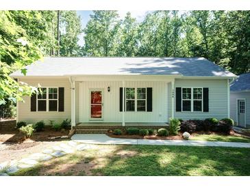 Charming single-story home featuring a welcoming front porch, well-maintained lawn and mature trees at 1006 Oxford Ridge Rd, Wake Forest, NC 27587