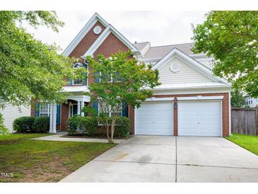 Traditional brick home featuring an attached two-car garage and well-manicured landscaping at 201 Masterwood Way, Morrisville, NC 27560