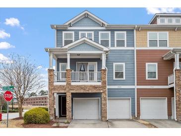 Charming two-story townhome featuring stone accents, a balcony, and individual garages at 2060 Jersey City Pl, Apex, NC 27523