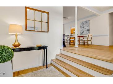 Bright foyer with hardwood floors, console table, lamp, decorative mirror and view into dining area at 244 Sweet Bay Pl, Carrboro, NC 27510