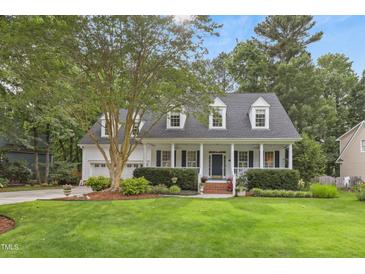 Charming two-story home featuring a covered front porch, beautiful landscaping, and a well-manicured lawn at 314 Chanticlair Dr, Apex, NC 27502